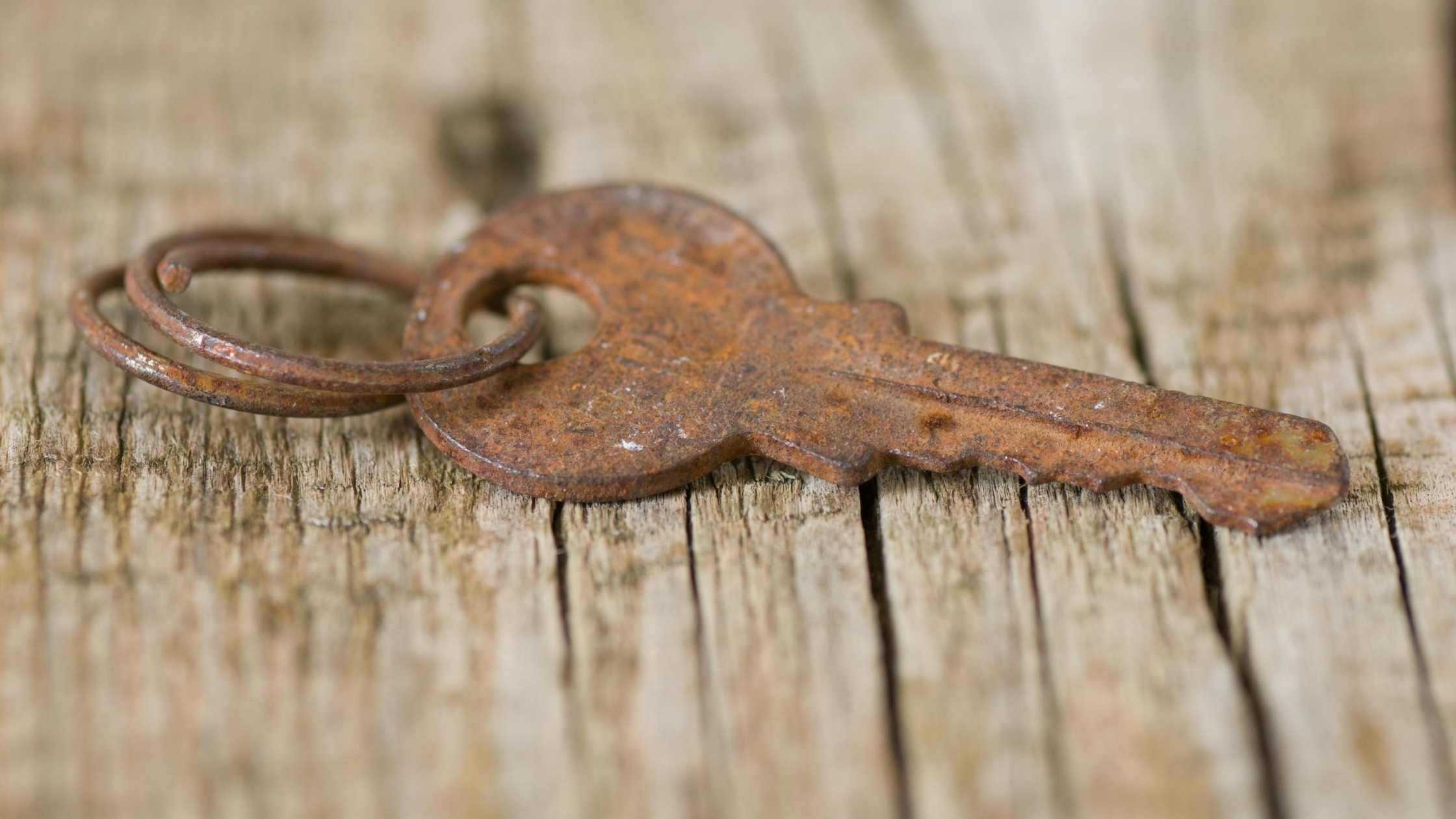 API key concept; Rusty key on wooden board