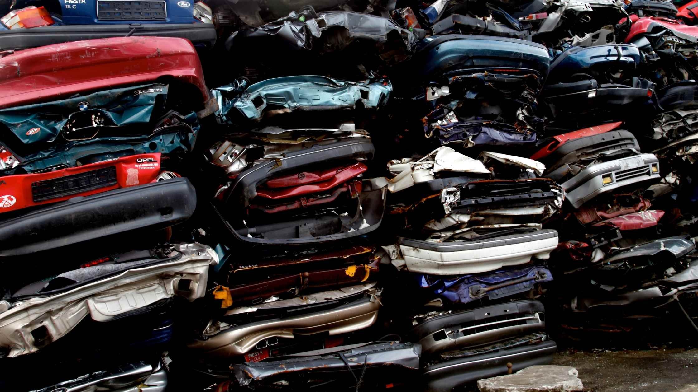 Car scrapyard, pile of crushed vehicles in junk yard