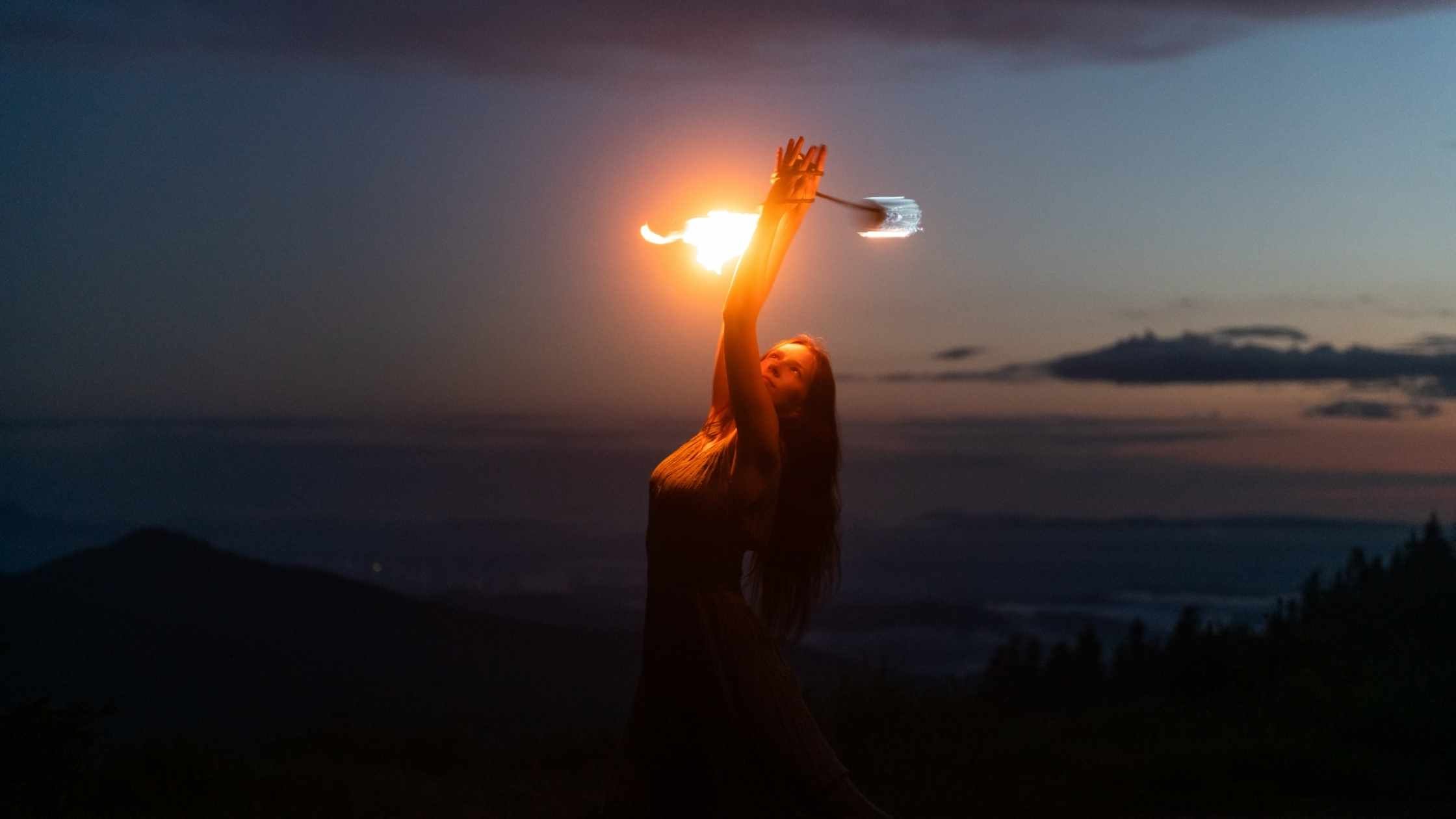 Graceful red haired female fire show performer