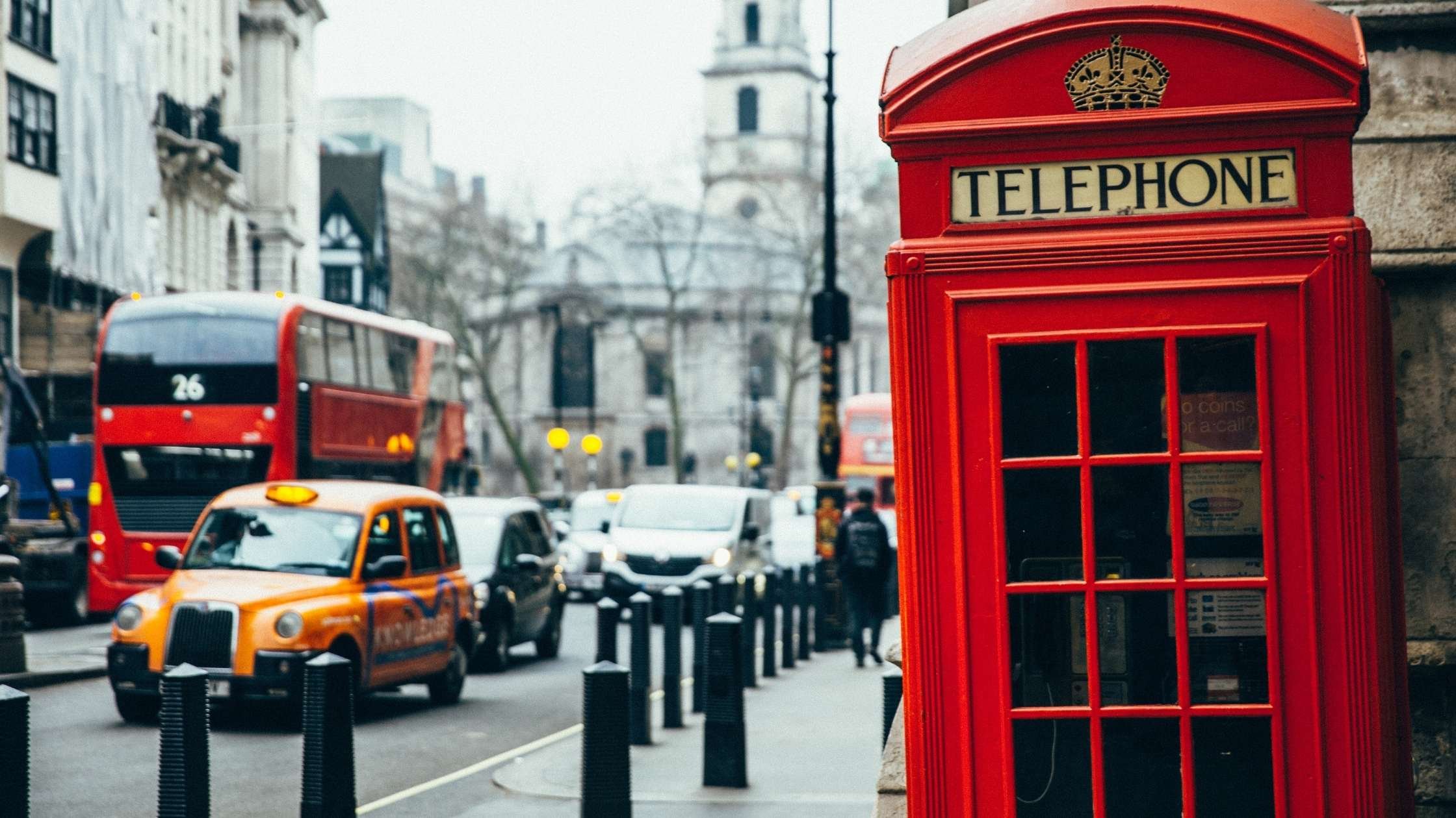 London street view showing traffic; red telephone box in foreground