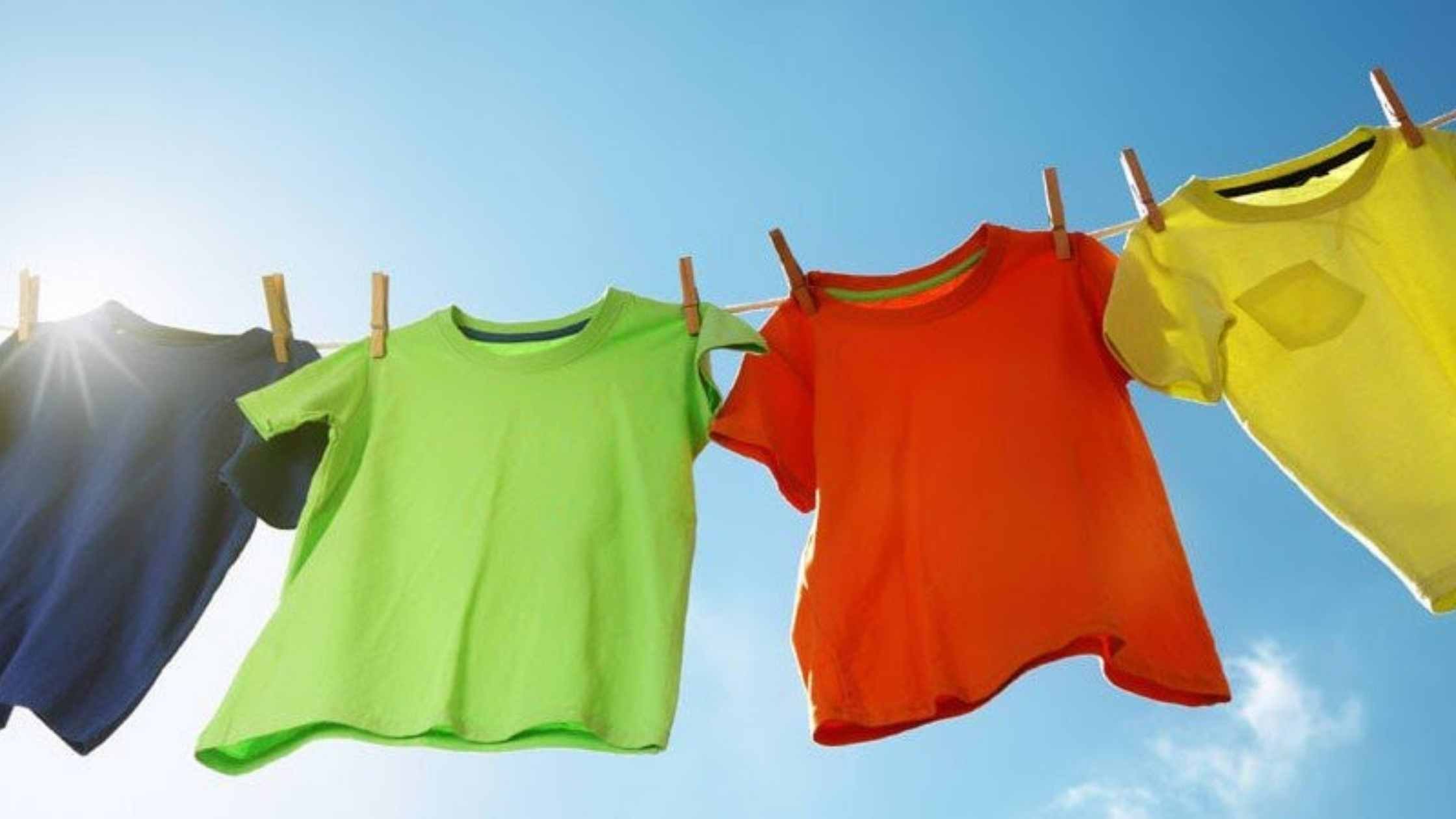 Pinning concept; Colourful t-shirts on a washing line, blue sky in background