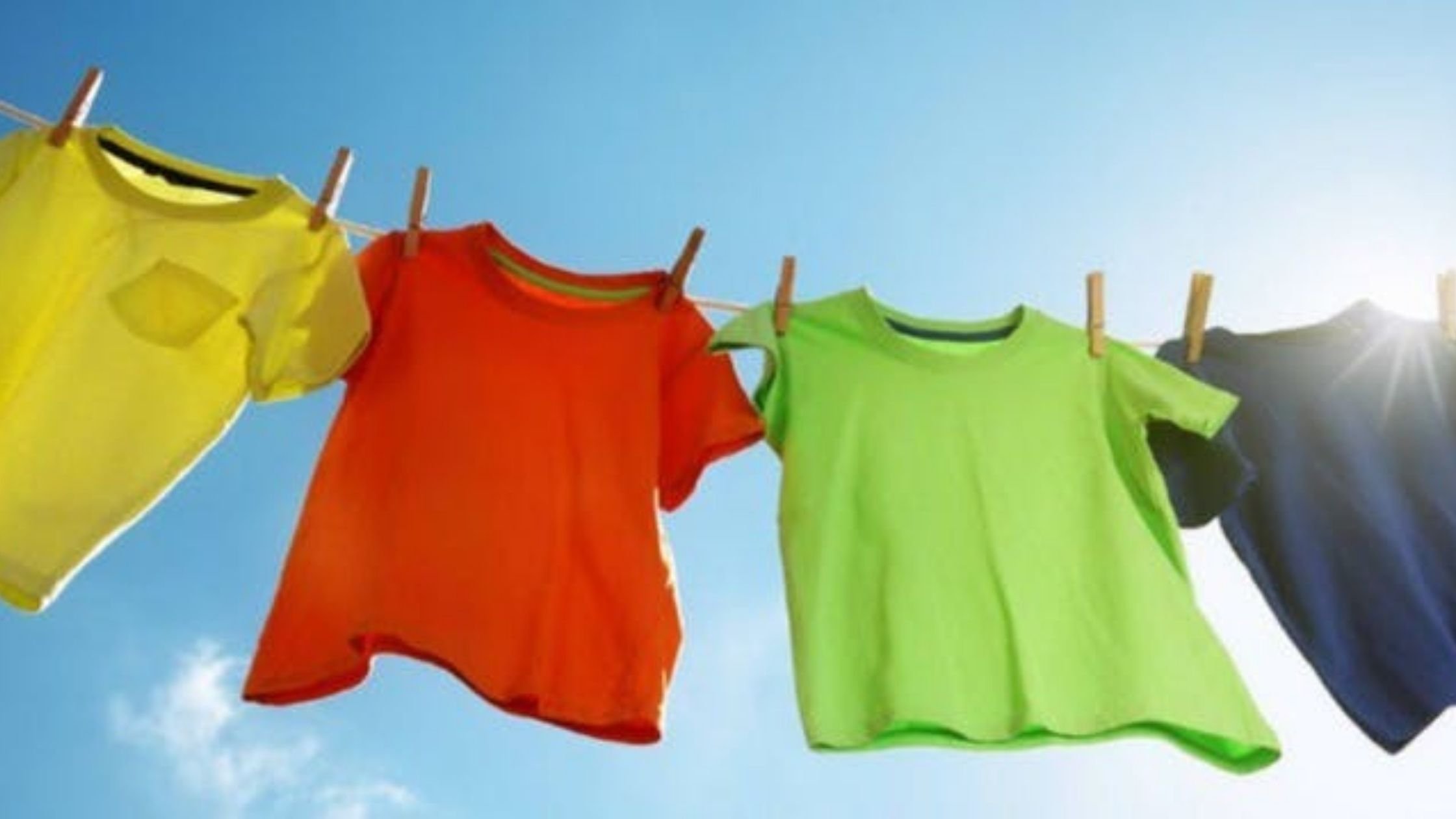 Pinning concept; colourful t-shirts pegged on washing line