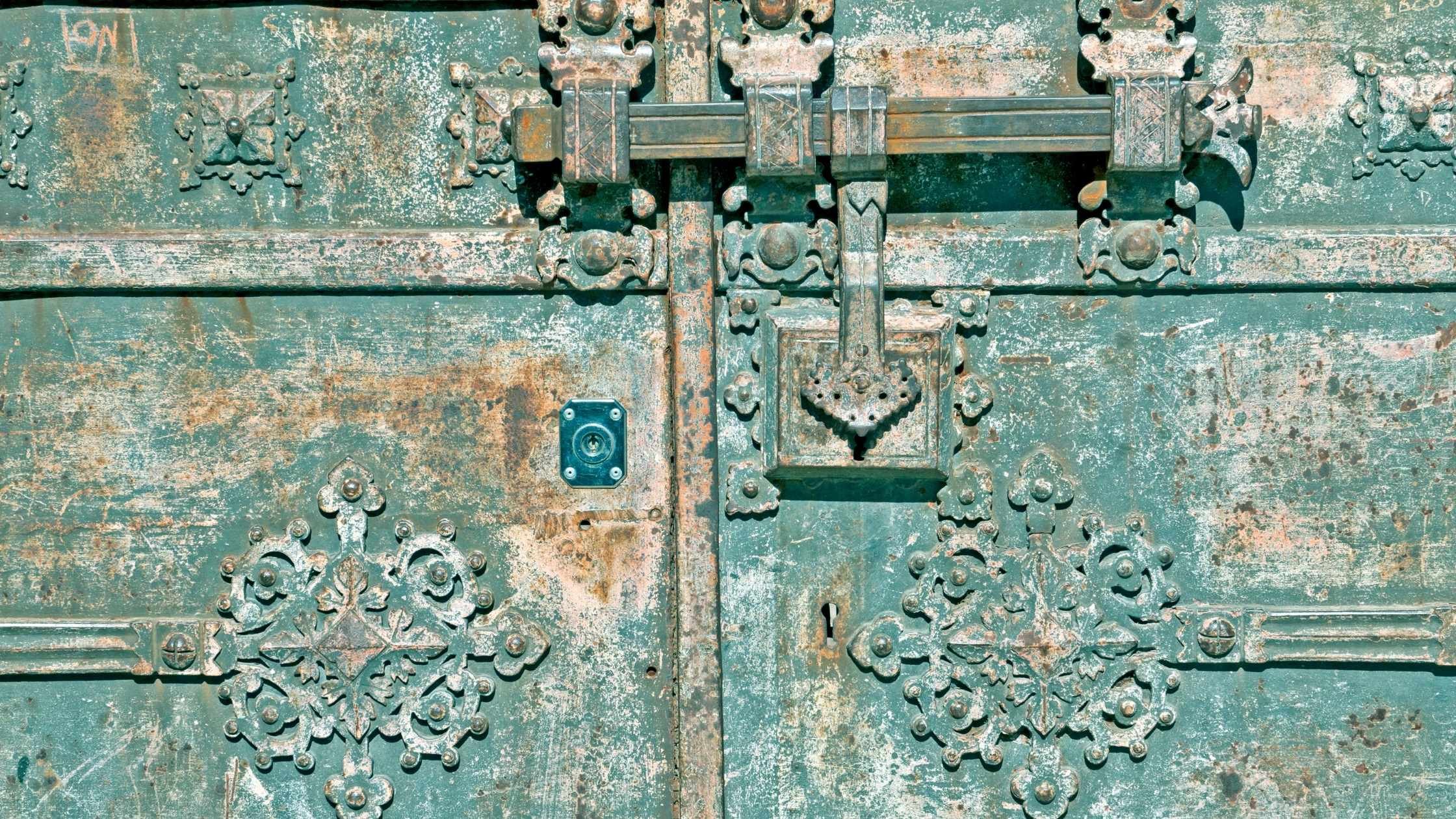 Security concept; old ornate metal gate with multiple locks
