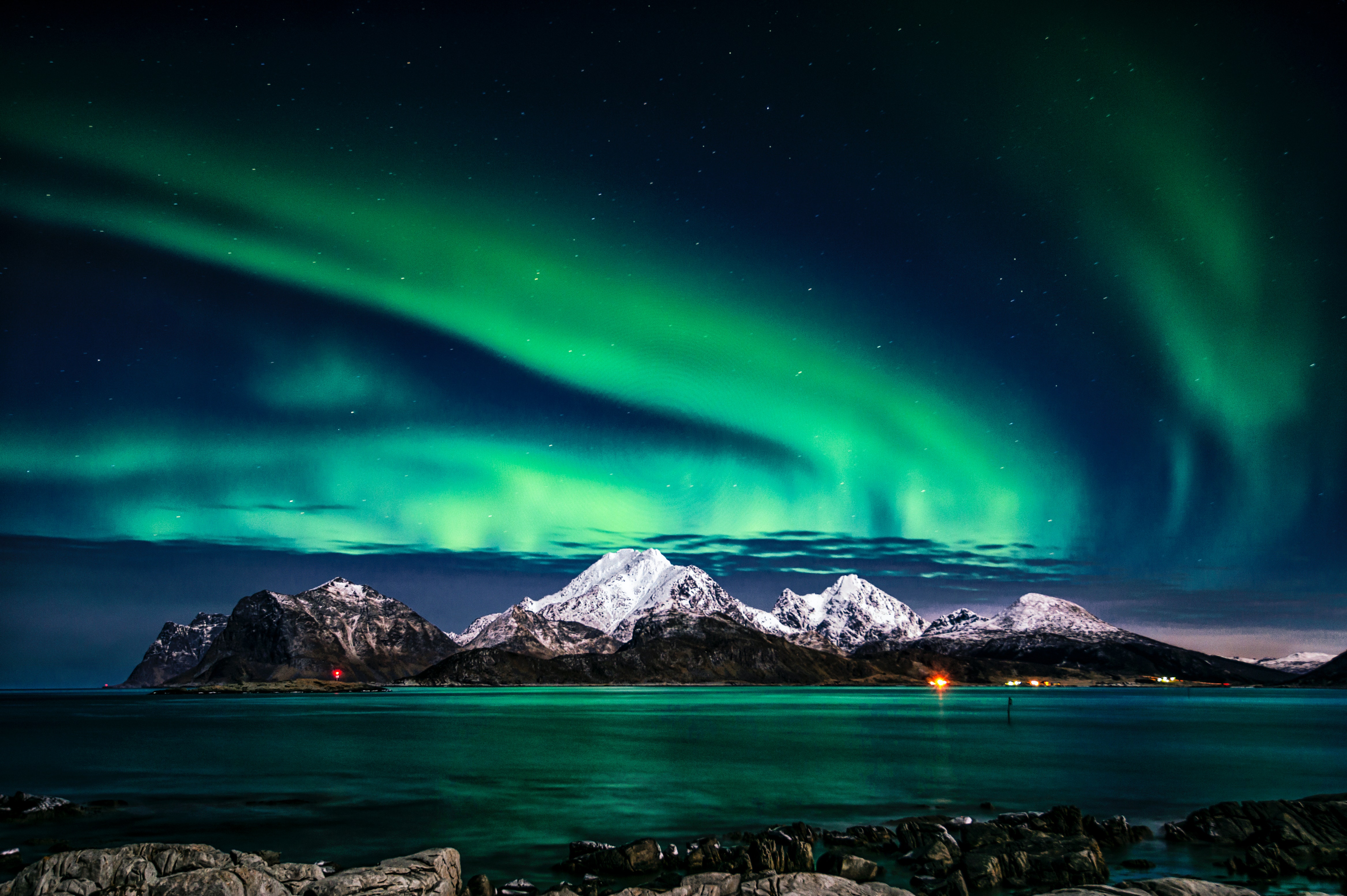 Aurora borealis over sea and mountain