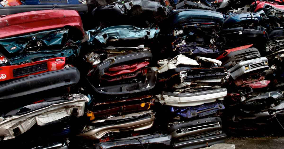 Car scrapyard, pile of crushed vehicles in junk yard