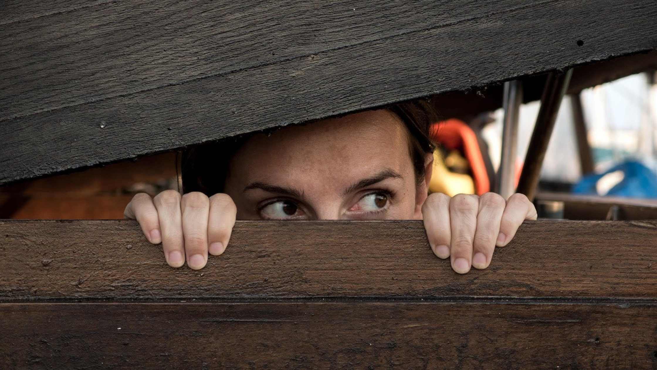 Person hiding in wooden crate