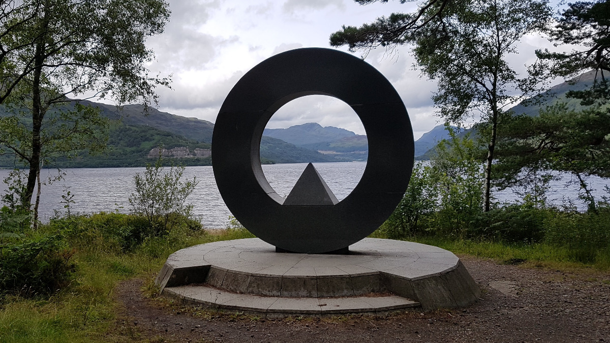 Rounded portal surrounded by trees with Loch Lomond in the background
